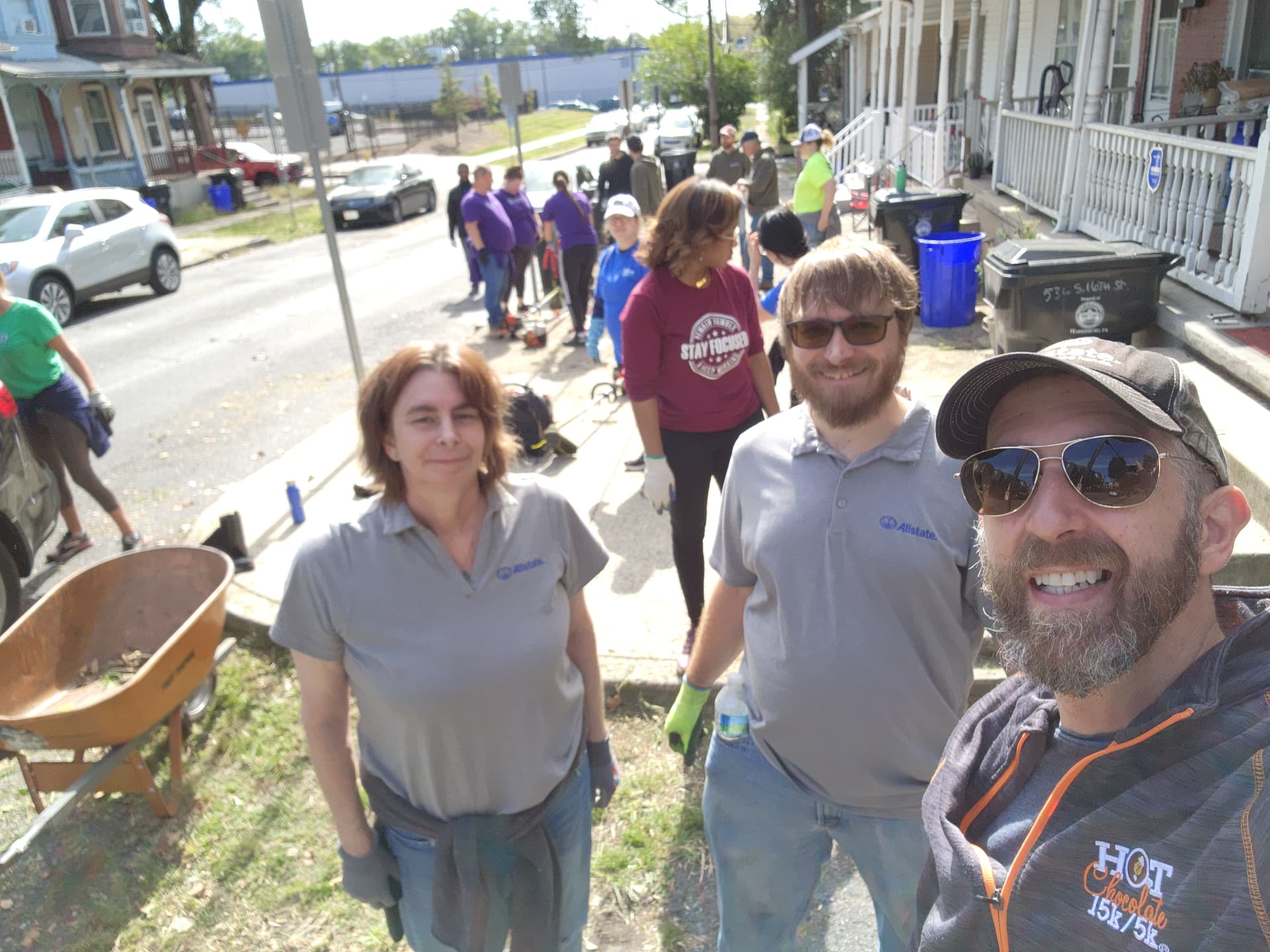 Agency team members with a wheelbarrow during a neighborhood street cleanup